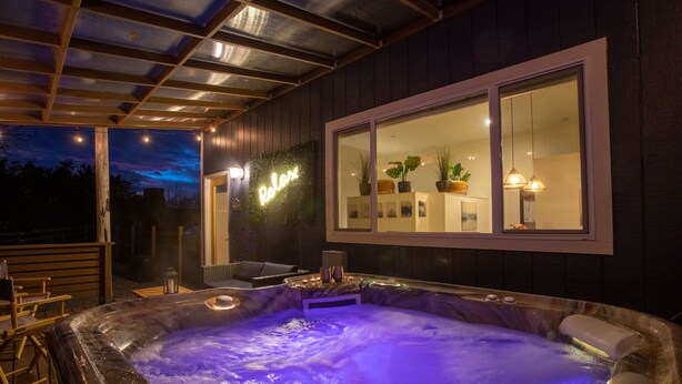 Ein Whirlpool mit Blick auf ein Haus und einen Sternenhimmel.