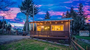 Eine Holzjagdhütte mit Veranda und einem Neonzeichen, auf dem 'Relax' steht.