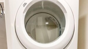 Un appareil combiné lave-linge et sèche-linge, de type « empilable », doté d’un panneau de commande et d’une porte transparente.