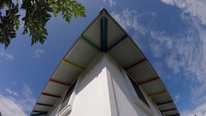 A white building with a triangular roof and a window. - Somewhere Over Rainbow Loft - Hilo NEW (Hilo)