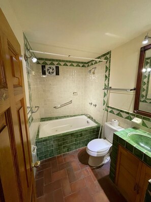 Familiekamer | Badkamer | Een bad/douchecombinatie, een haardroger, handdoeken, zeep