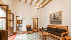 A traditional room with a patterned floor, wooden furniture, and a chandelier. - Hotel Meson de Isabel (Querétaro)