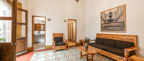 Una habitación tradicional con piso estampado, muebles de madera y un candelabro.