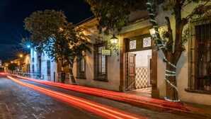 A historic street with cobblestone pavement, traditional architecture, and decorative lighting. - Hotel Meson de Isabel (Querétaro)