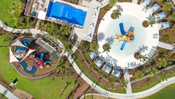 An aerial view of a resort with a swimming pool, a water slide, and a circular water feature. - Townhome with Screened Pool, Kids Bedrooms, Near Attractions (Kissimmee)