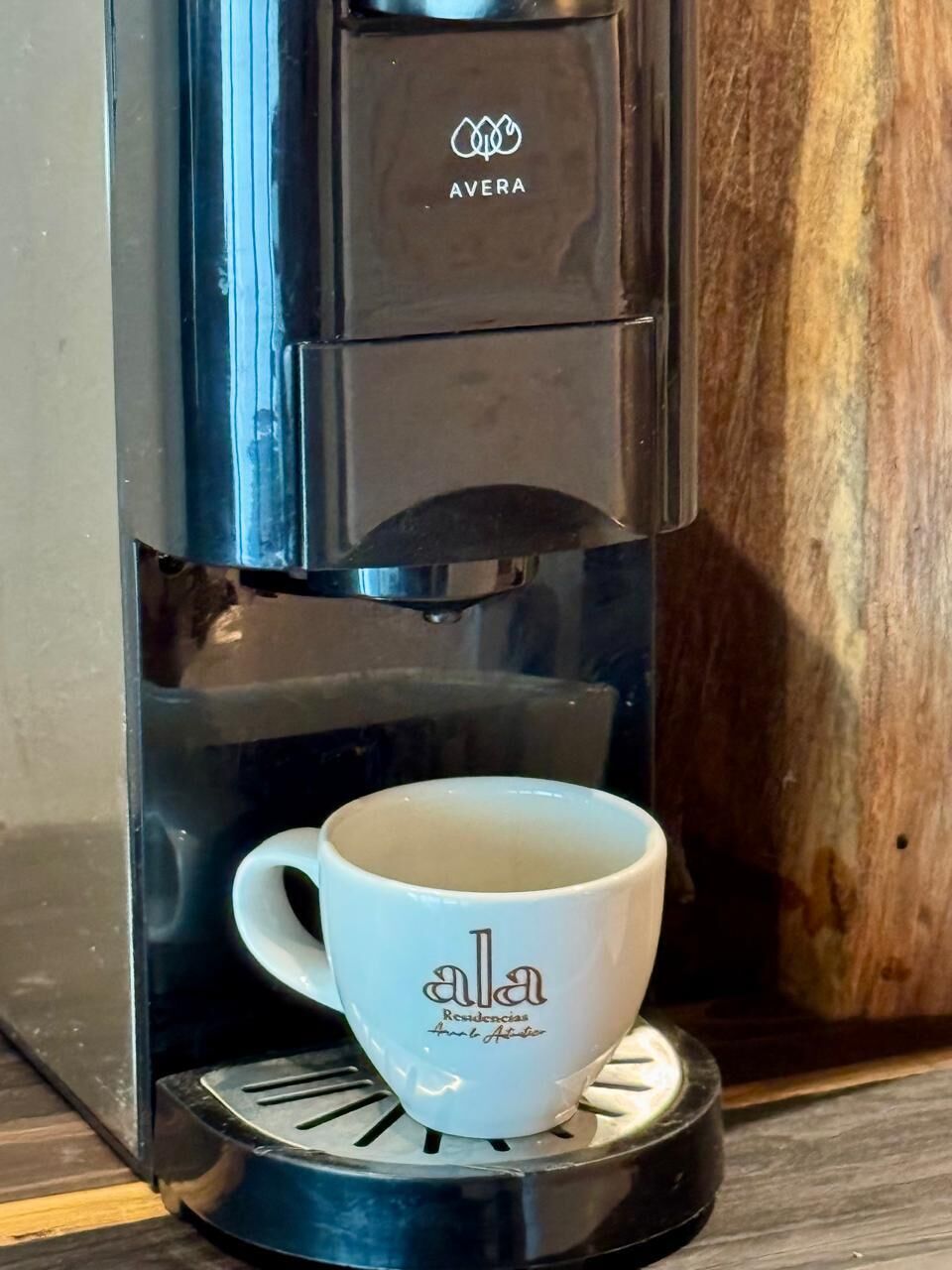 A coffee machine with a cup on its drip tray.