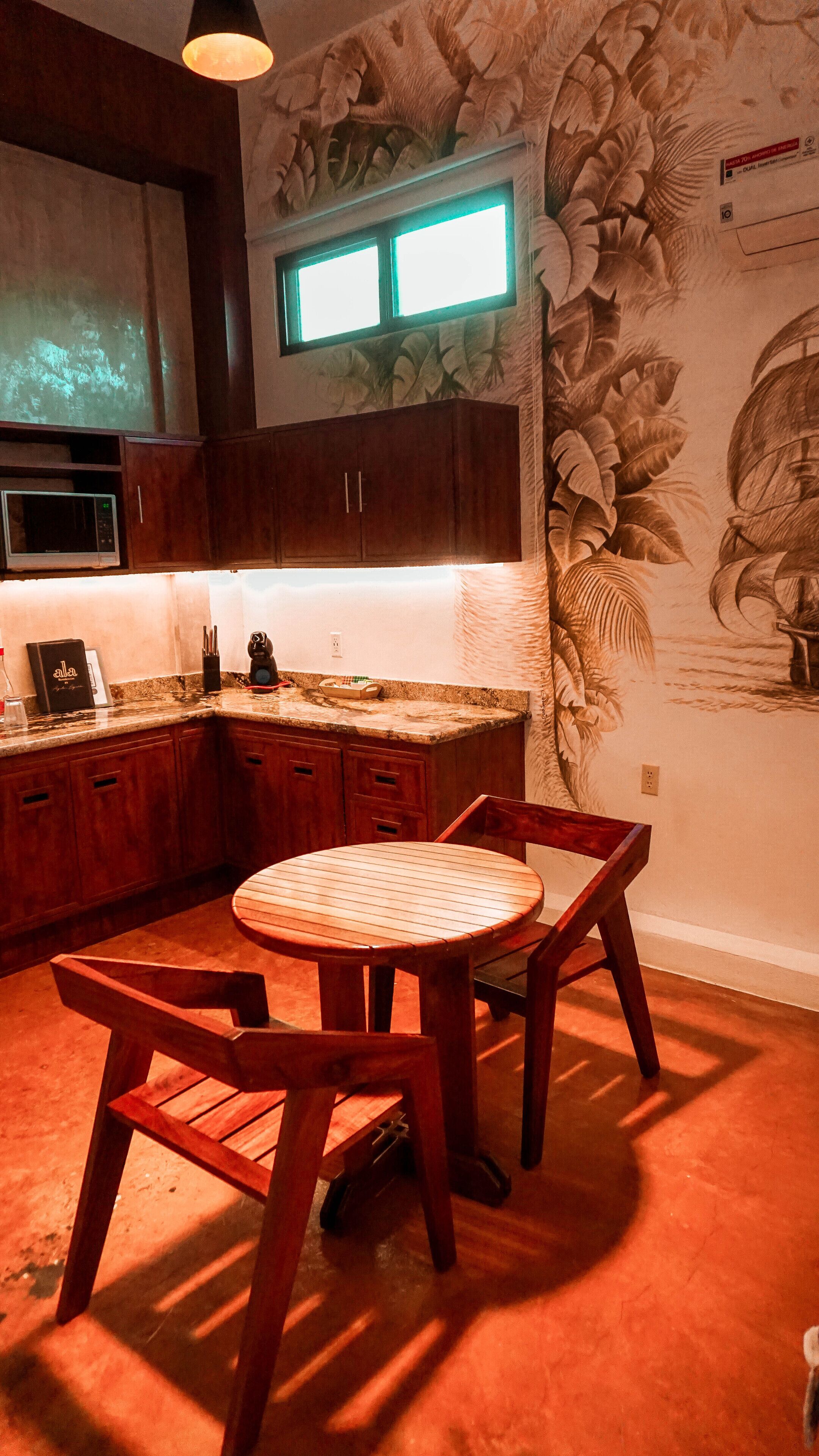 A kitchen with wooden cabinets, a microwave, and a table with chairs.