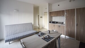 A modern kitchen with wooden cabinets, a dining table with chairs, and a built-in bench. - Gallipoli Italy Luxury Residence (Gallipoli)