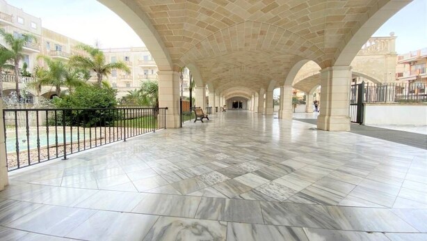An open covered walkway with a tiled floor, arches, and a view of buildings in the background. - Gallipoli Italy Luxury Residence (Gallipoli)