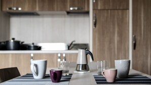 A modern kitchen with wooden cabinets, a stainless steel kettle, and a striped tablecloth. - Gallipoli Italy Luxury Residence (Gallipoli)
