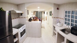 A modern kitchen with a central island, a built-in oven, and a stainless steel refrigerator. - Cozybeautiful house near to the beach (Acapulco de Juárez)