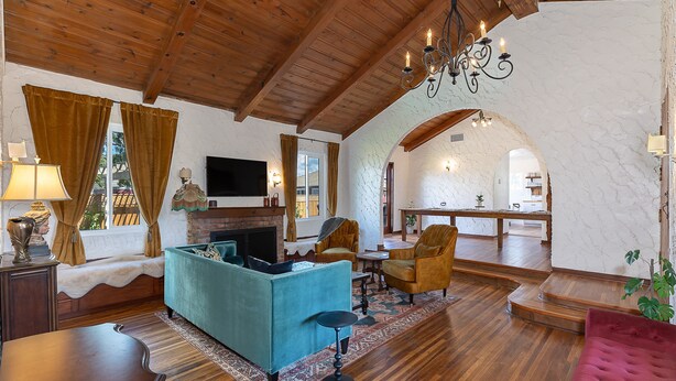 A spacious living room with a fireplace, wooden ceiling, and a cozy seating area. - Completely Renovated Old Time Los Alamos Home-- with recreation Barn! (Los Alamos)