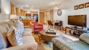 A modern living room with a sofa, armchair, coffee table, and TV stand. - Westwind 308 2BD Gold Condo With A/C in Lionshead Village (Vail)