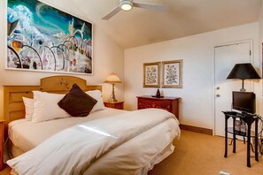 A hotel room with a large bed, a ceiling fan, a painting, a lamp, a television, and a door. - Westwind 404 3BD 3BA Platinum Condo in Lionshead Village (Vail)