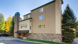 A two-story building with a stone base and wooden upper levels, featuring a sign that reads "Westwind at Vail." - Westwind 109 1BD 1.5ba Gold Condo in Lionshead Village (Vail)