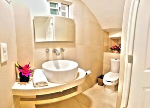 Ein Badezimmer mit einem großen Waschbecken, einem Spiegel darüber und einer Toilette.