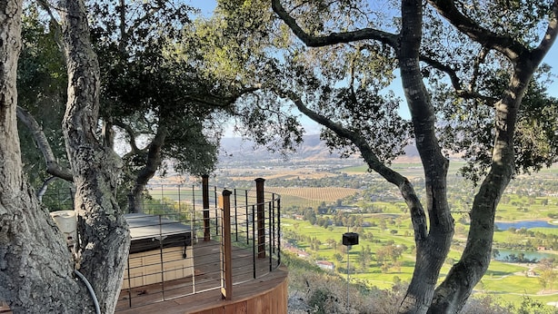 A wooden deck with a view of a valley.