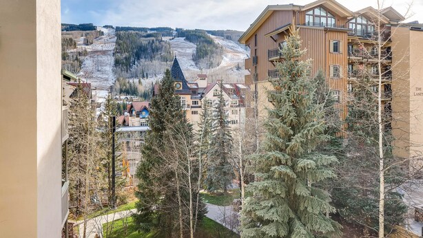A view of a residential area with buildings, trees, and a distant ski slope. - Westwind 406 2BD 2BA Diamond Condo in Lionshead Village (Vail)