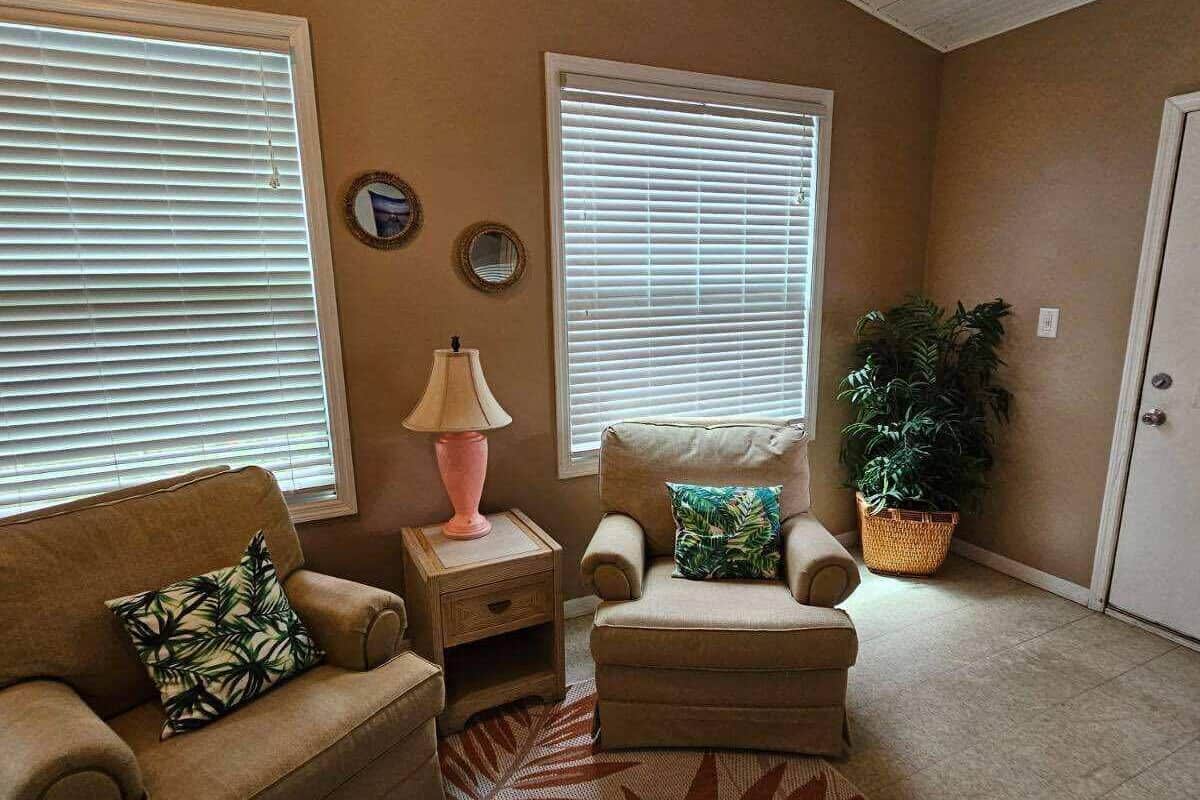 A living room with two sofas, a coffee table, a patterned rug, and a potted plant.
