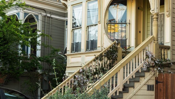 A two-story house with a prominent front staircase, large windows, and a decorative front porch. - B-Love's Guest House (Oakland)