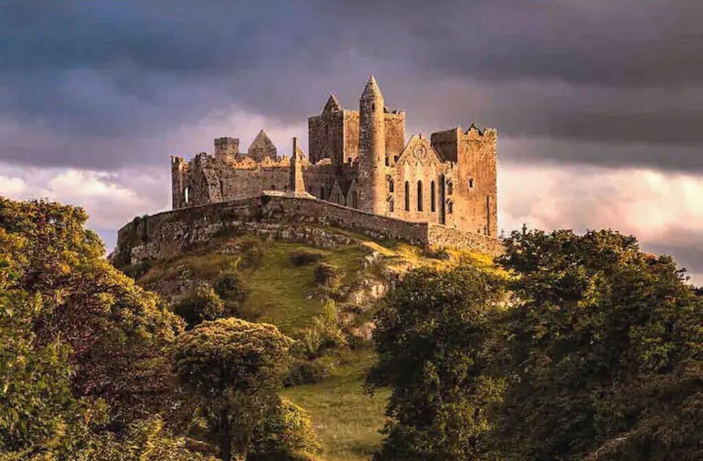 Un castillo histórico en una colina, con un muro fortificado y varias torres.