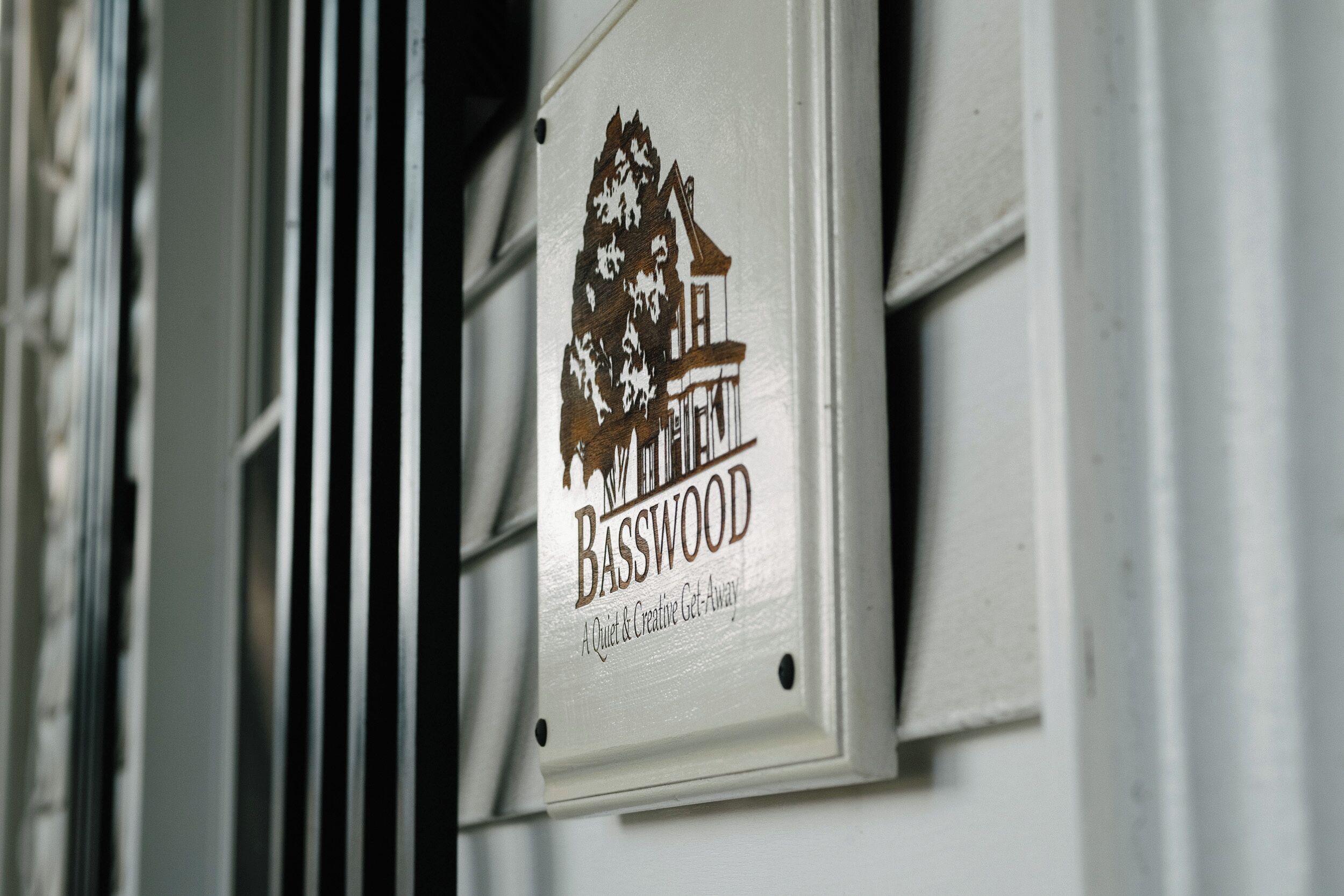 Une pancarte avec l’inscription « Basswood » et la description : « Un lieu paisible et propice à la créativité. »