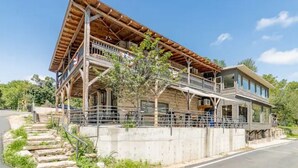 Ein zweistöckiges Gebäude mit Balkon und überdachter Veranda.