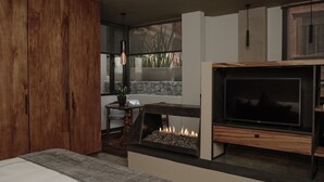 Una sala de estar moderna con chimenea, armarios de madera y una pared de piedra.