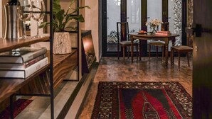Un comedor acogedor con una mesa de madera, sillas y un tapete estampado.