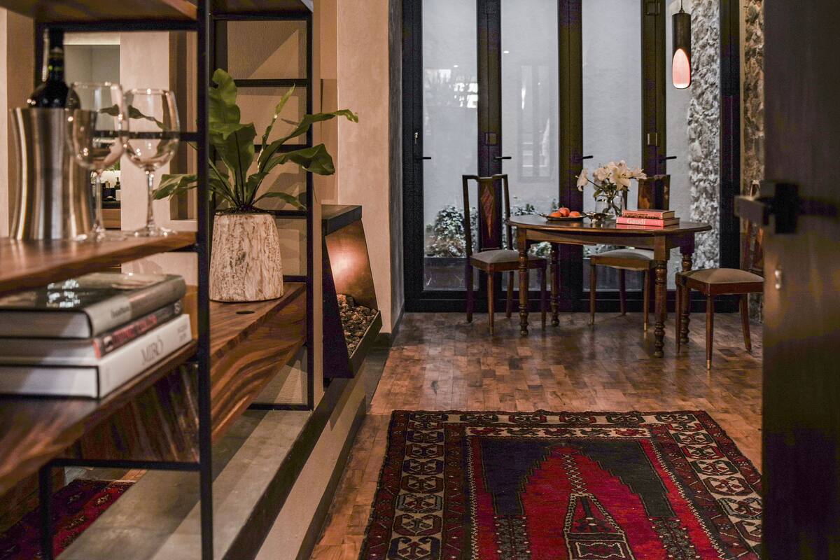 A cozy dining area with a wooden table, chairs, and a patterned rug.