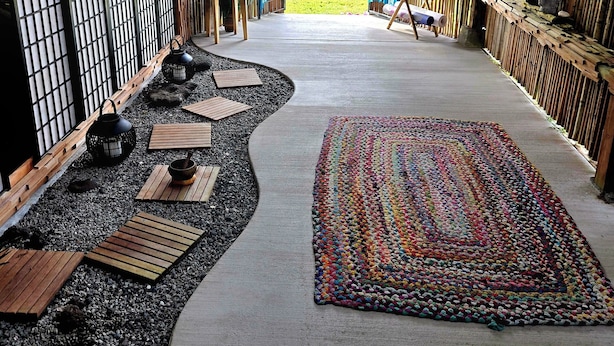 Une pièce de style japonais traditionnel, avec un sol recouvert de tatamis, un paravent en papier de riz (shoji) et une vue sur un jardin luxuriant.
