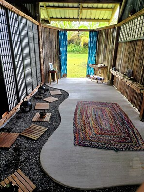 Une pièce de style japonais traditionnel, avec un sol recouvert de tatamis, un paravent en papier de riz (shoji) et une vue sur un jardin luxuriant.