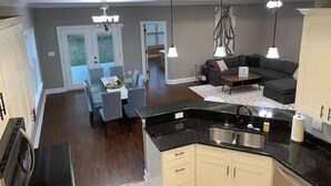 Una cocina amplia con comedor, una sala de estar con sofá y una mesa de comedor con sillas.