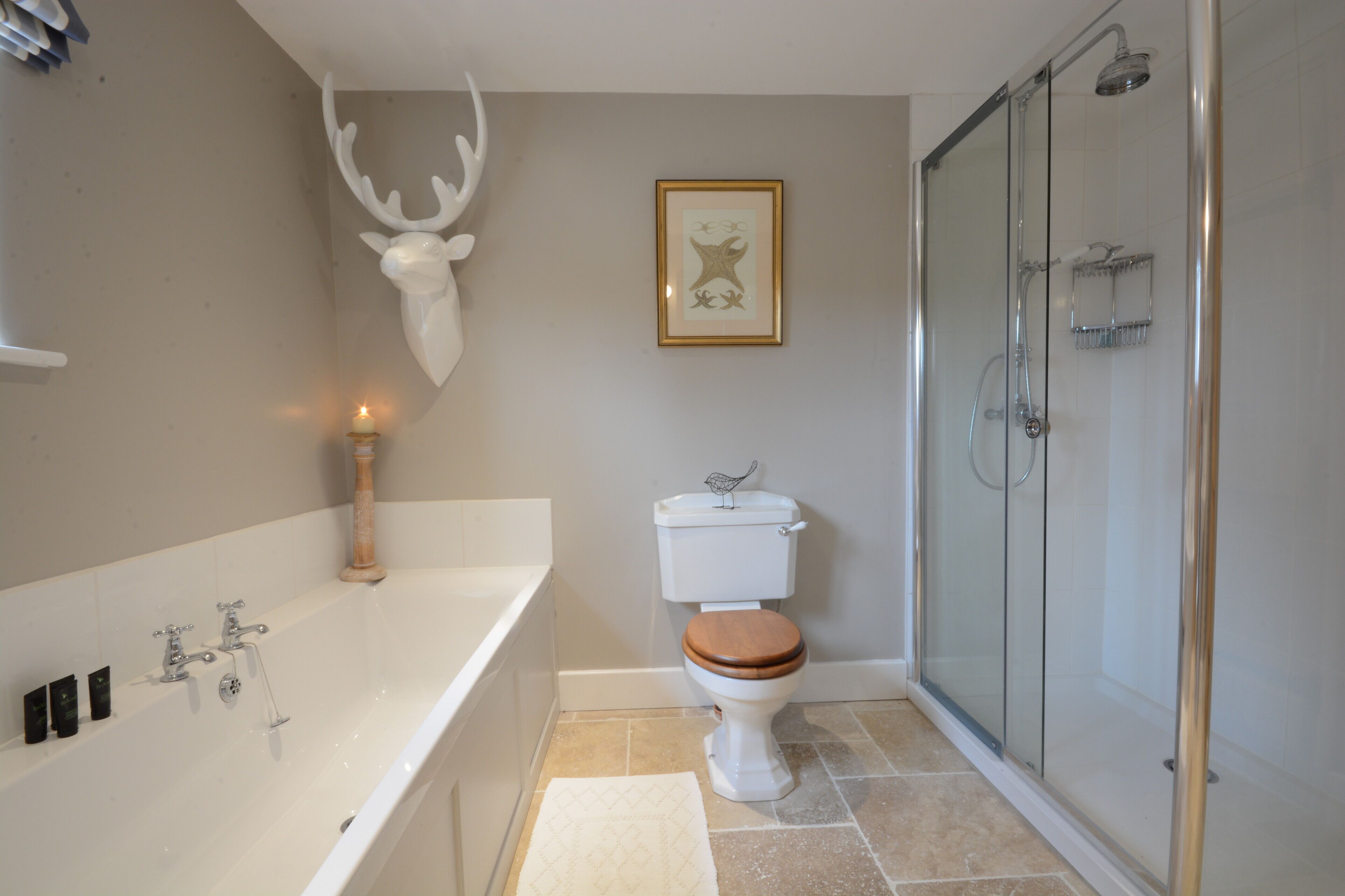 A bathroom with a bathtub, toilet, and glass shower enclosure.