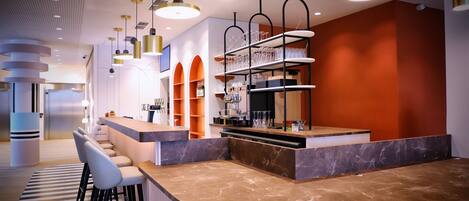A modern bar area with a curved marble countertop, multiple bar stools, and a shelf with glassware.