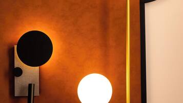 A wall-mounted light fixture with two spherical lights and a smaller circular light.