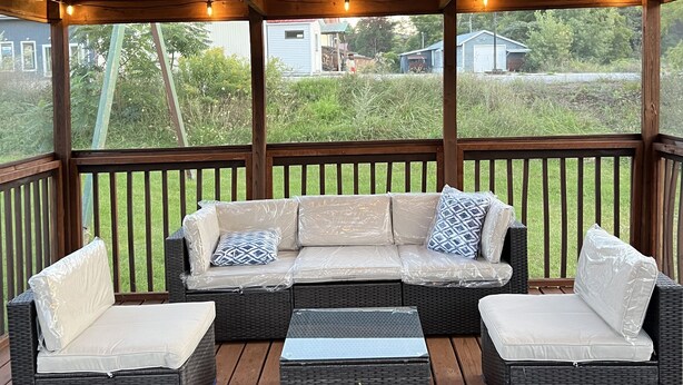 A covered outdoor seating area with a ceiling fan, a cushioned sofa, and two armchairs. - High Peaks Haven is in the heart of Adirondack. Come enjoy with famil (Keeseville)