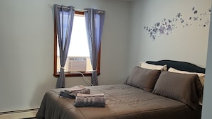 A bedroom with a bed, curtains, a wall decoration, and a ceiling light. - High Peaks Haven is in the heart of Adirondack. Come enjoy with famil (Keeseville)
