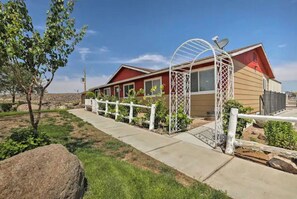 Situated in a landscaped setting, this single-story building features a garden enclosed by a white metal fence.