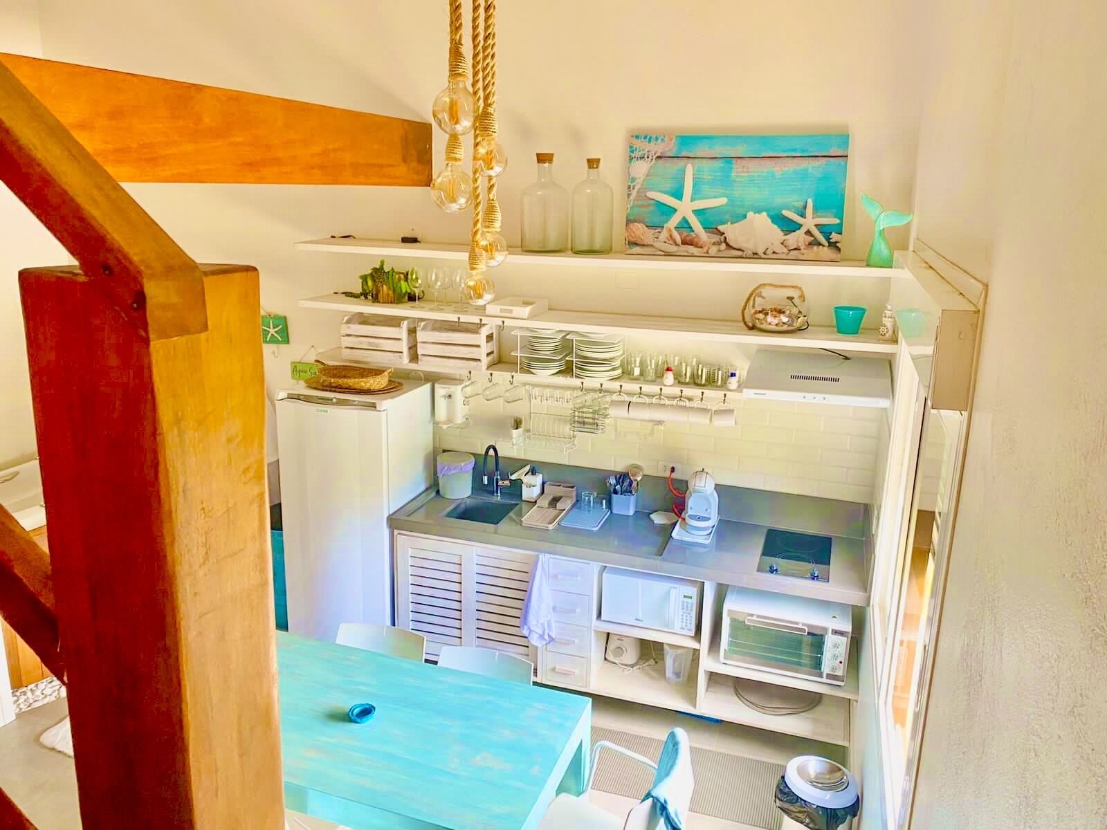 A kitchen with white cabinets, a sink, and a dining area with a blue table.