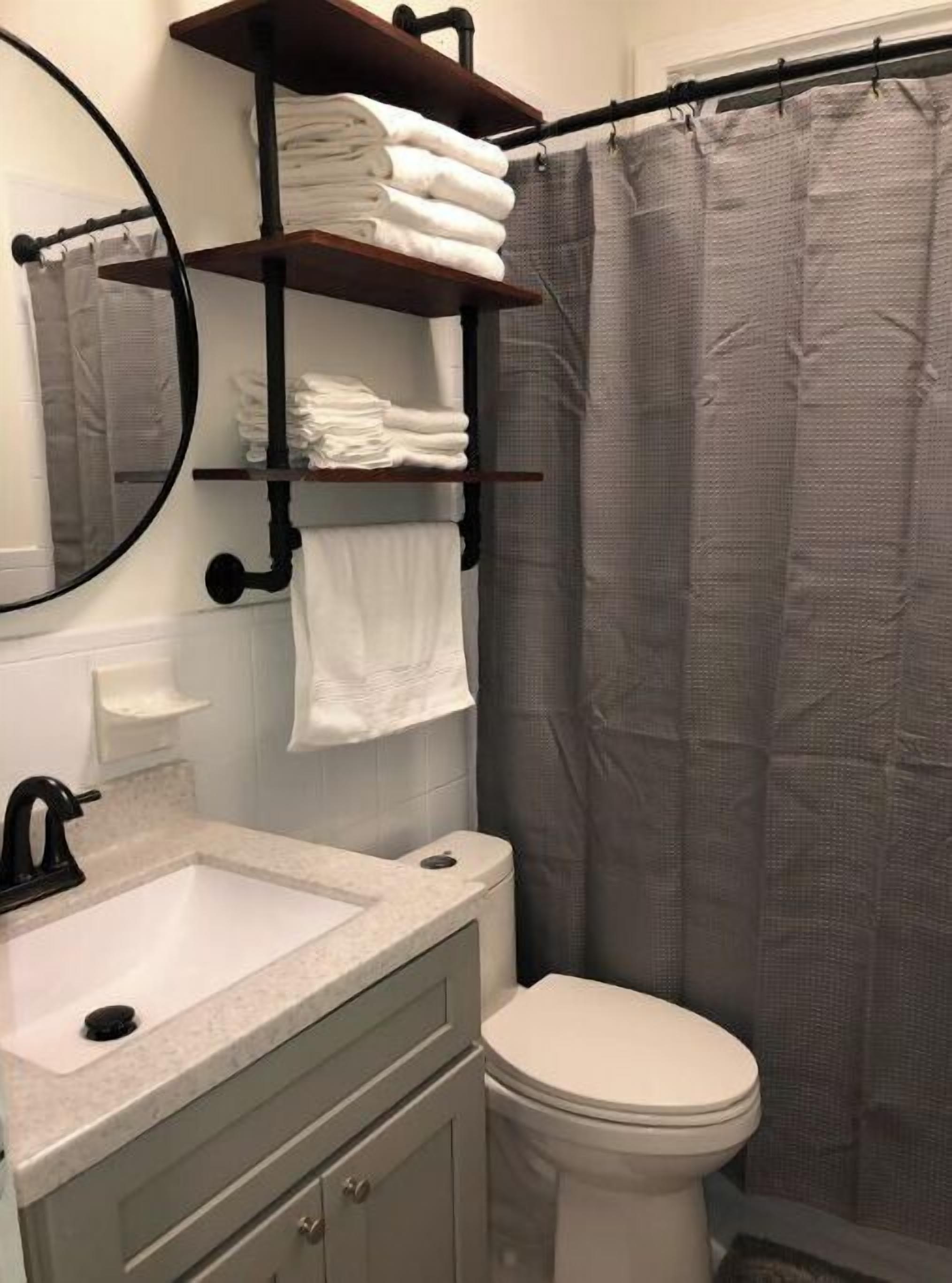 A bathroom with a sink, toilet, and a towel rack with folded towels.