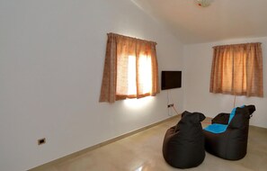 Relax in this serene living space with a flat-screen TV and comfortable seating.
