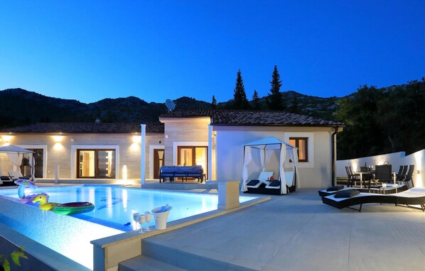 Relax by the spacious pool surrounded by comfortable lounge chairs and a dining area.