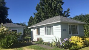 Einbungalow mit der Hausnummer 445, umgeben von einem gepflegten Garten mit verschiedenen Pflanzen und Blumen.