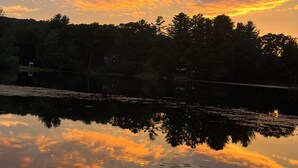 A calm lake at sunset with trees reflecting the sky. - Visit your kids at uconn and get away (Mansfield)
