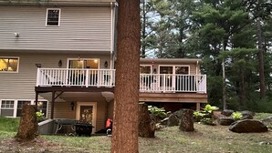 A two-story house with a balcony, surrounded by trees and rocks. - Visit your kids at uconn and get away (Mansfield)