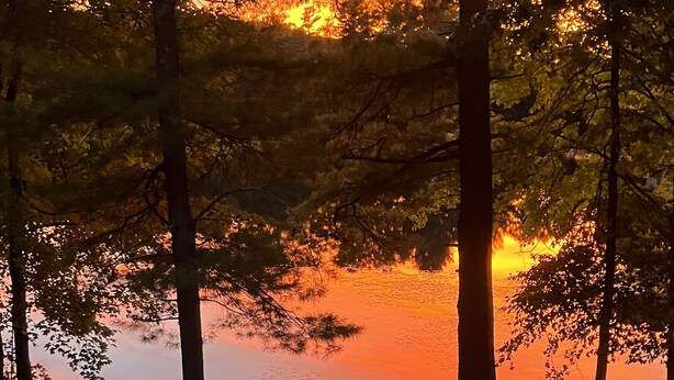 A campsite with a kayak, chair, and a bucket near a lake at sunset. - Visit your kids at uconn and get away (Mansfield)
