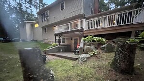 A two-story house with a deck, a small porch, and a stone wall. - Visit your kids at uconn and get away (Mansfield)