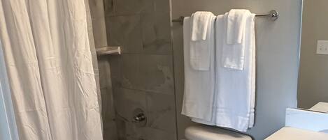 シャワー付き浴槽、タオル、トイレットペーパー