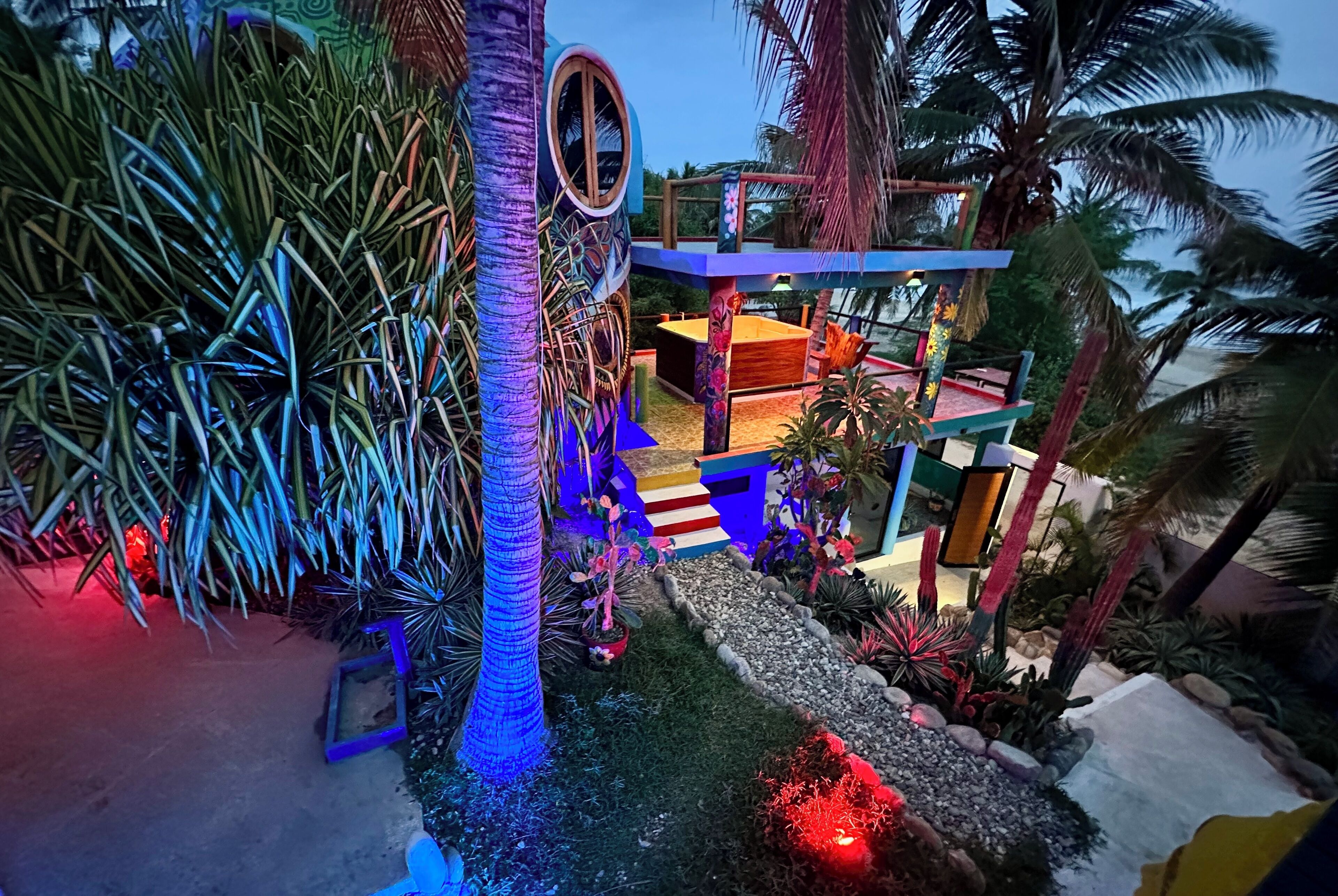 A multi-level outdoor area with a pool, palm trees, and a staircase.